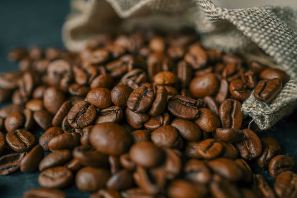 istock Coffee beans in a wooden plate on a black background 2148448198