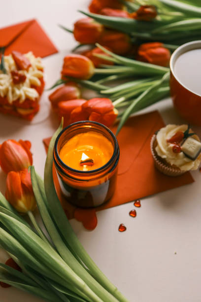 istock Candle and bouquet of red tulips, spring aesthetics 2148448441