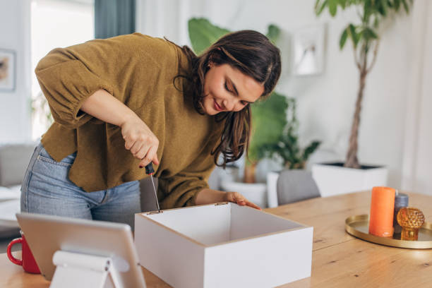 istock Young woman assembling furniture at home 2148448980