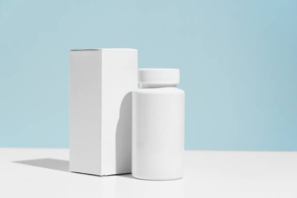 White mockup box and plastic pill jar on blue background. Concept of dietary supplements, vitamins to improve health and immunity, medicine and pharmacy