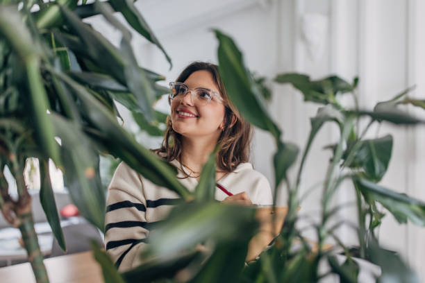 istock Joyful woman relaxing amidst houseplants 2148449867