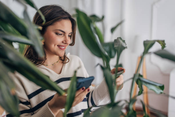 istock Young woman enjoying time at home with plants 2148450070