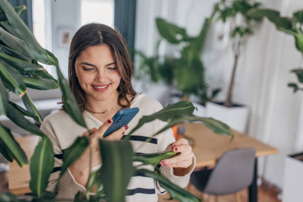 istock Young woman enjoying time at home with plants 2148450082