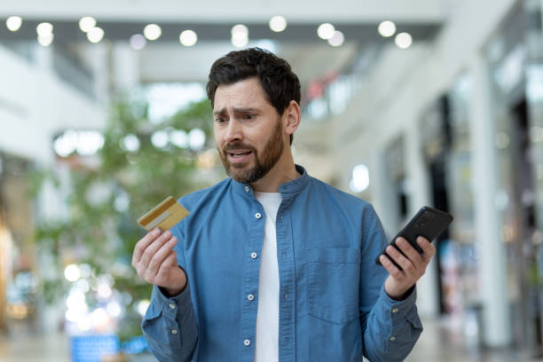 istock Man feeling confused with credit card and smartphone in mall 2148450746
