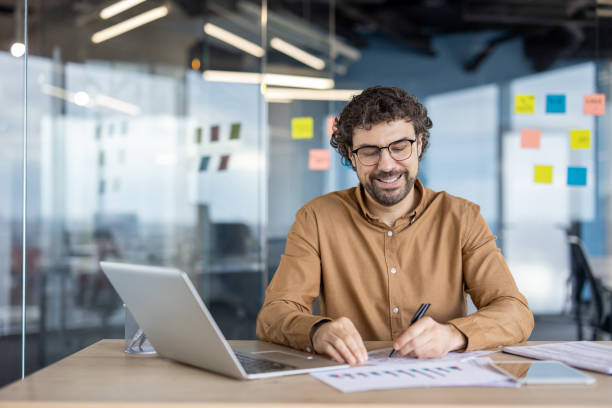 istock Mature Hispanic businessman smiling while working in office 2148451935