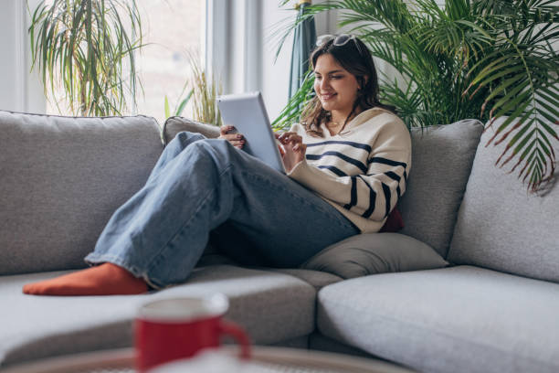 istock Young woman enjoying a relaxing day at home with her tablet 2148452304