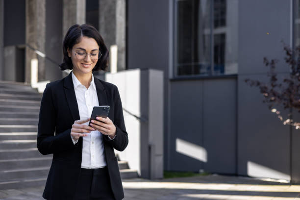 istock Professional businesswoman using smartphone outdoors - modern corporate lifestyle 2148452309