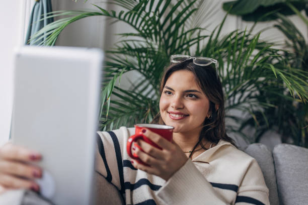 istock Relaxed young woman enjoying coffee at home 2148452412