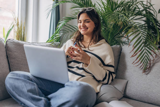 istock Young woman enjoying laptop time at home 2148452649