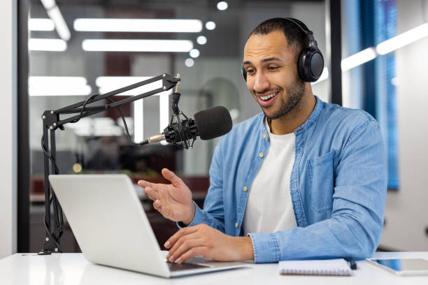 istock Indian man podcasting from home in a modern living room 2148452690