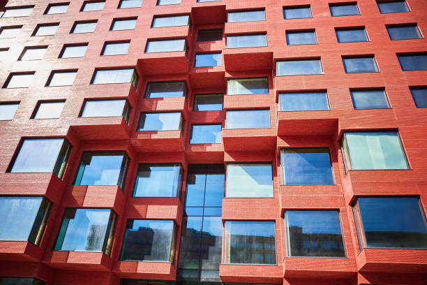 istock Part of a new multi-story red office building under construction from below 2148452773