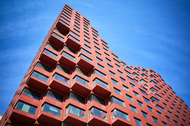 istock Part of a new multi-story red office building under construction from below 2148452776