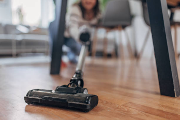 istock Young woman cleaning with vacuum at home 2148452810