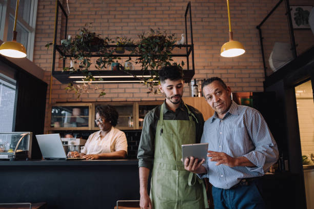 istock Coffee shop owner talking to employee 2148453705