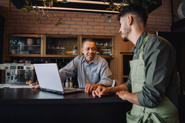 istock Coffee shop owner talking to employee 2148453747