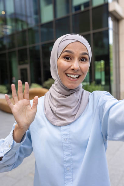 istock Woman in hijab taking a vertical selfie and smiling broadly 2148453858
