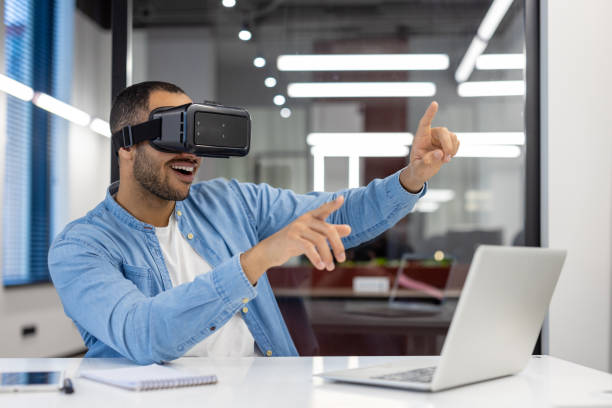 istock Indian businessman experiencing virtual reality in office 2148454116