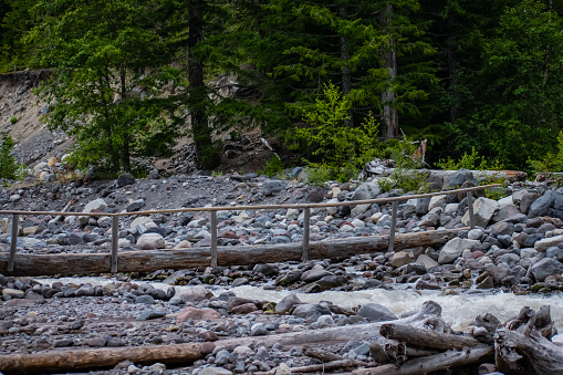 A log bridge crossing over the Nisqually River, running off of the Nisqually Glacier on the south face of Mount Rainer, Washington USA.