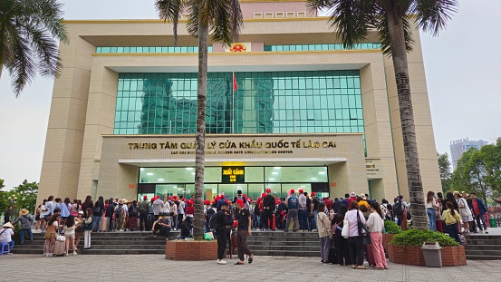 Lao Cai, Vietnam - March 30, 2024: Tourists line up to enter the border gate official building in Lao Cai, Vietnam to check in before walking to China.