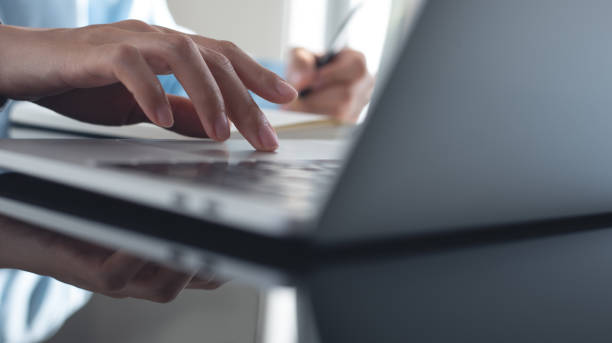 istock Business woman working on laptop computer and writing note on notebook. Female student searching the information on laptop computer during online studying, e-learning,  business planning 2148455461