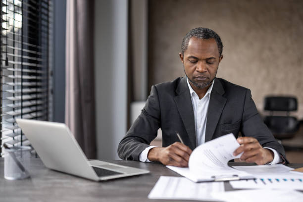 istock Professional african american businessman reviewing documents in office 2148455727