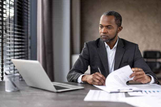 istock Professional businessman reviewing documents at desk 2148455764