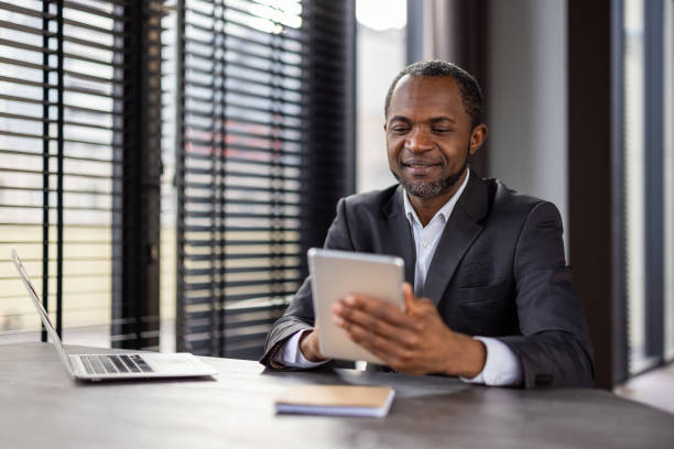 istock Professional african american businessman in office using digital tablet with laptop 2148457214