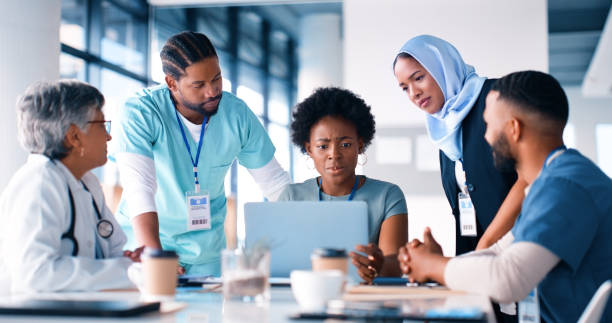 istock Doctors, laptop and team with meeting in hospital for results, planning or problem solving in medical service. Medic, women and men with group by computer for research, report or discussion in clinic 2148457353