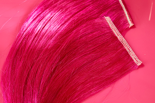 Hot pink hair swatch on pink background with copy space