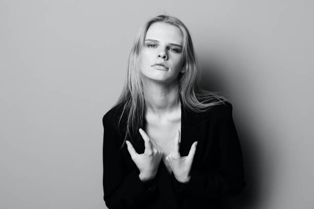 istock Gorgeous young stylish lady in jacket posing leaning on the wall at studio. Pretty female blonde model sexy looking at camera 2148458062