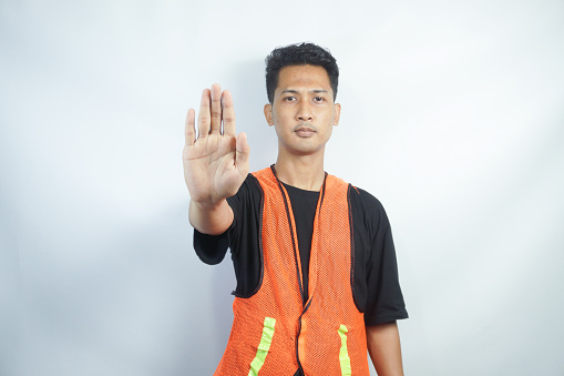 asian workman wearing orange safety vest or work fest making stop gesture