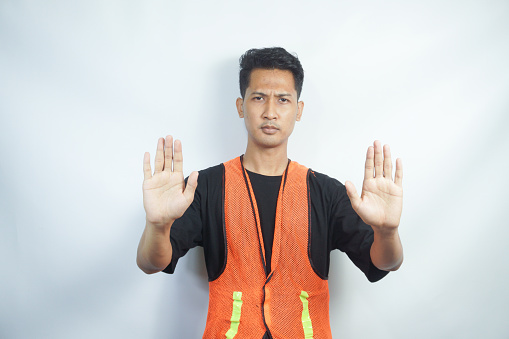 asian workman wearing orange safety vest or work fest making stop gesture