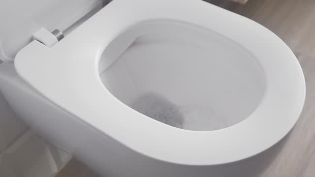 A full flush in the toilet with a large flow of fresh water into the sewer.