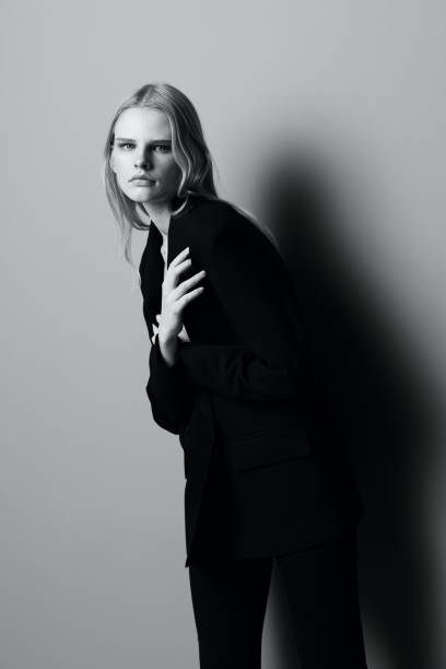 istock Blonde in a suit hugs herself while putting on a jacket 2148459136