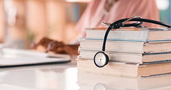 Nurse, research and medical books for cardiology or coronary heart disease, blood pressure or education. Person, stethoscope and studying for biology healthcare breakthrough, internship or learning