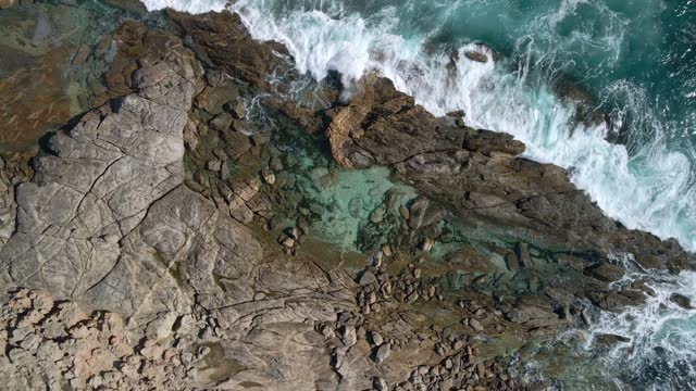 Top down drone view of tourists swimming at natural rock pool at Greenly Beach, Eyre Peninsula, South Australia