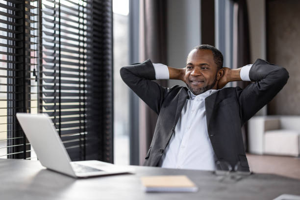 istock A man in a suit is sitting at a desk with a laptop and a notebook 2148459969