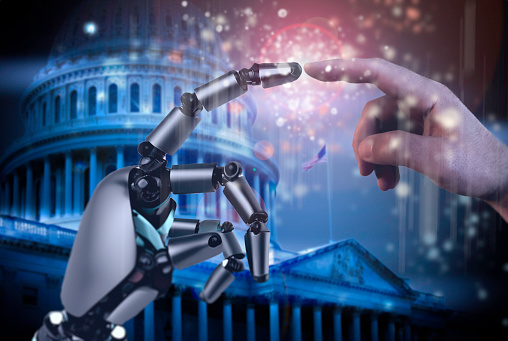 Photo of the United States Capitol overlayed with human and robot fingers meeting.  Leveraging artificial intelligence to support the human experience.