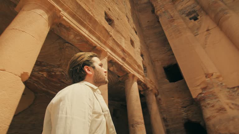 Man walking towards Petra and Carved Sandstone