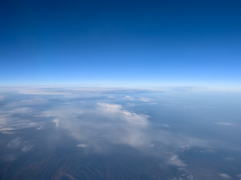 View from the porthole to the blue horizon and the earth under the clouds. High quality photo