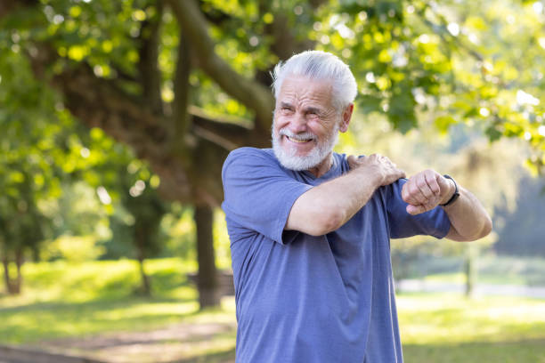 istock Senior gray-haired man sprained his ankle while walking in the park and exercising, standing outside and massaging his shoulder with his hand and feeling severe pain 2148463598