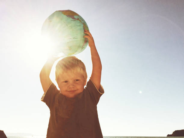 Portrait of charming positive schoolchild toothy smile hands hold planet earth globe isolated on pink color background.