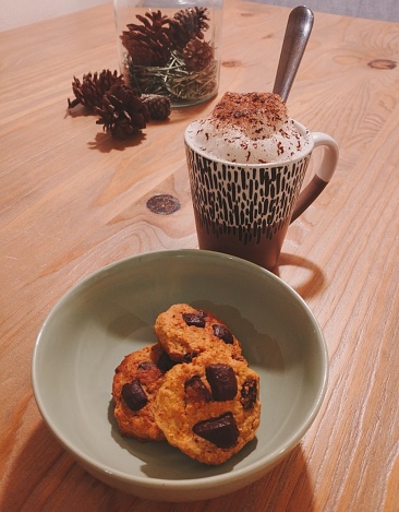 Taza de café con galletas de chocolate sobre una mesa de madera