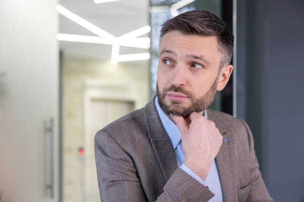 istock Businessman deep in thought against modern office backdrop 2148465689