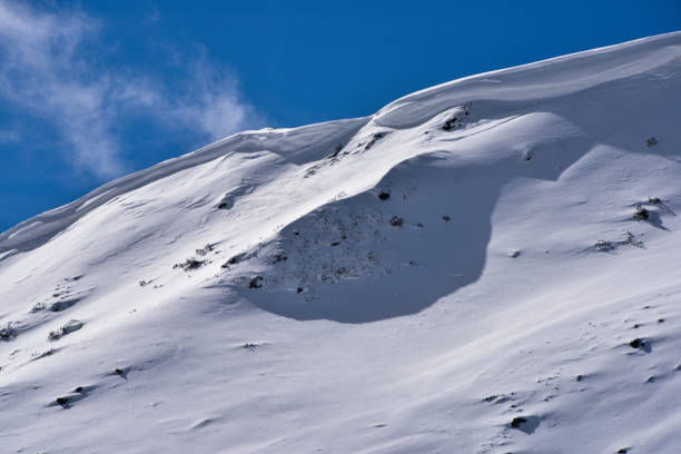 Snow trail follows him as he gains speed