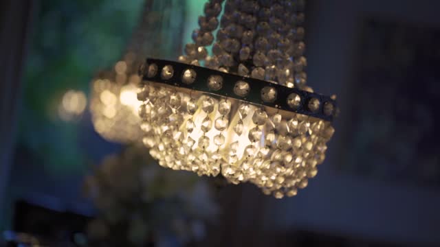 closeup of crystal chandelier hanging on the ceiling. Bokeh background of other chandeliers