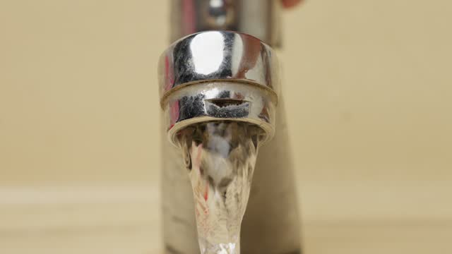 Water spilling from an open faucet