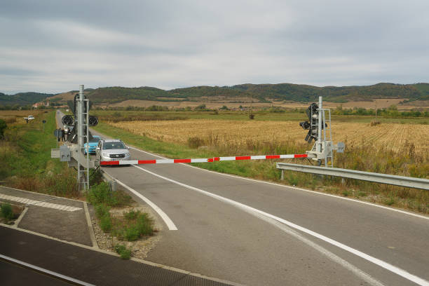 Hoghilag, Romania - October 09, 2023: Cars wait at a railway level crossing barrier