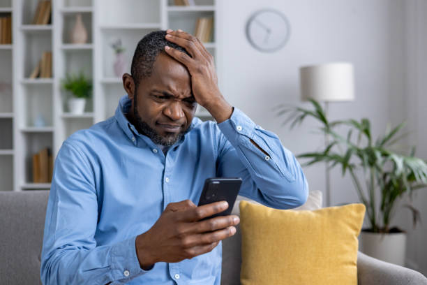 istock Distressed man discovering fraud on his mobile device 2148467370