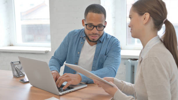 istock Business People Discussing Project on Laptop and Tablet 2148470038